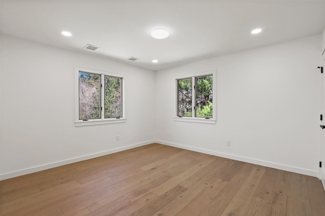 spare room with a wealth of natural light, visible vents, and baseboards