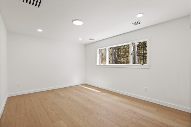 spare room featuring hardwood / wood-style floors, baseboards, and visible vents