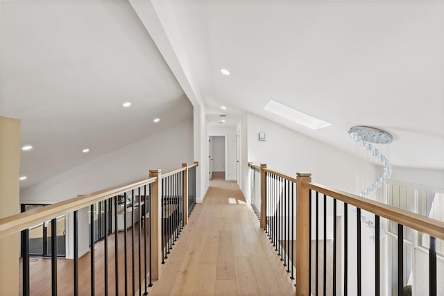 hallway featuring recessed lighting, an upstairs landing, light wood-type flooring, and vaulted ceiling with skylight