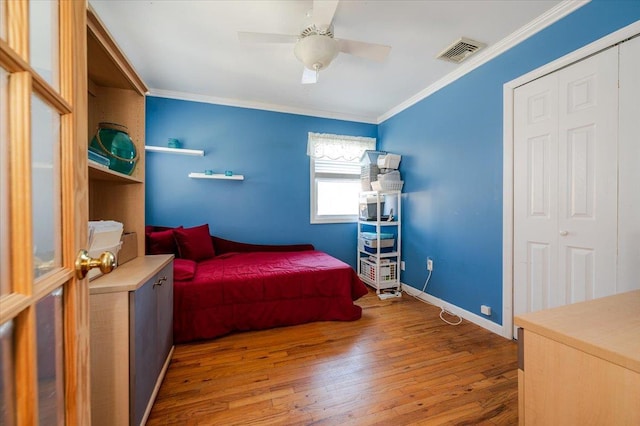 bedroom featuring baseboards, visible vents, ceiling fan, ornamental molding, and hardwood / wood-style floors