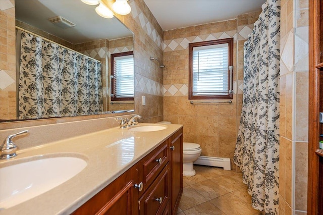 bathroom featuring a baseboard radiator, toilet, a sink, and tile walls
