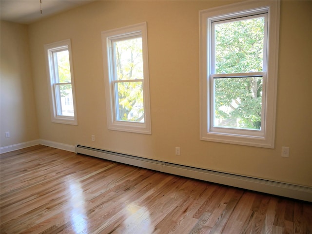 unfurnished room with light wood finished floors and baseboard heating