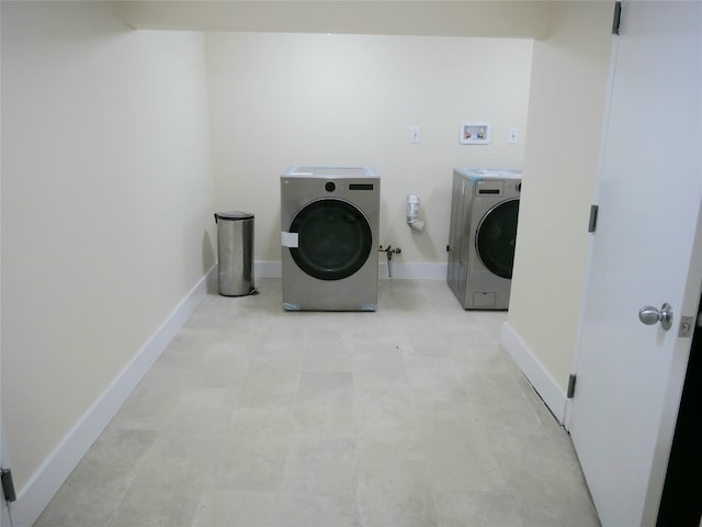laundry area with baseboards, washer and dryer, and laundry area