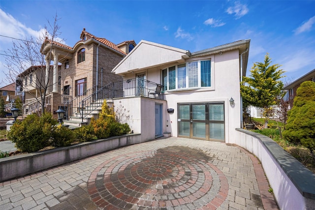 view of front of house featuring stucco siding and a patio