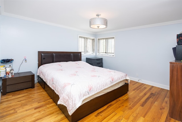 bedroom featuring baseboards, light wood-style floors, and crown molding