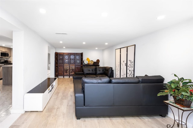 living area featuring light wood finished floors and recessed lighting