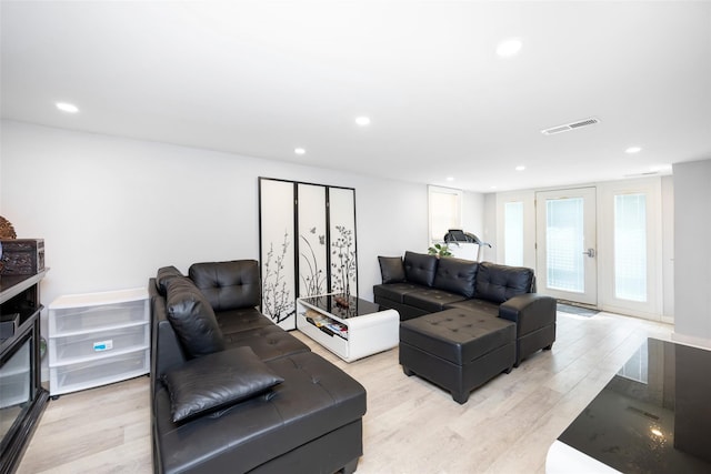living room with light wood-style flooring, visible vents, and recessed lighting