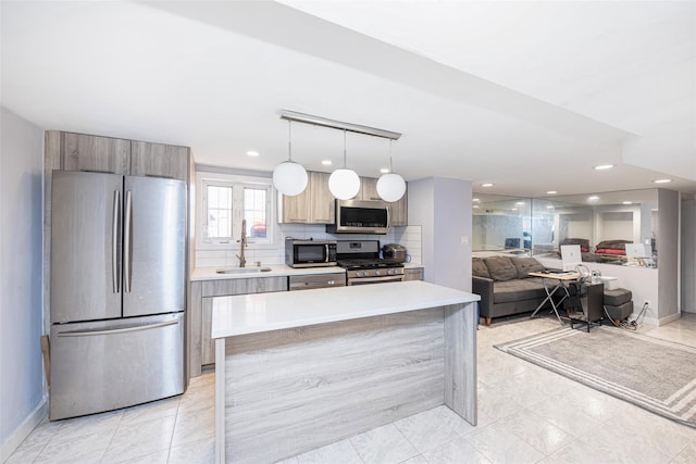 kitchen featuring light countertops, a sink, tasteful backsplash, appliances with stainless steel finishes, and modern cabinets