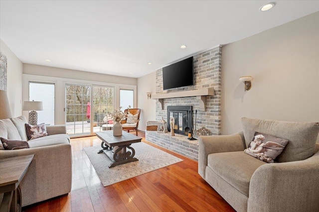 living room with a fireplace, recessed lighting, and wood-type flooring
