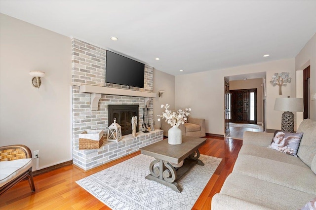 living room with baseboards, a fireplace, wood finished floors, and recessed lighting