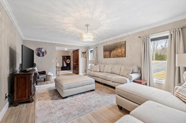living area featuring baseboards, a notable chandelier, crown molding, and light wood-style floors
