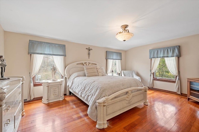 bedroom featuring baseboards and light wood finished floors