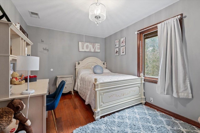 bedroom featuring dark wood finished floors, baseboards, a chandelier, and visible vents