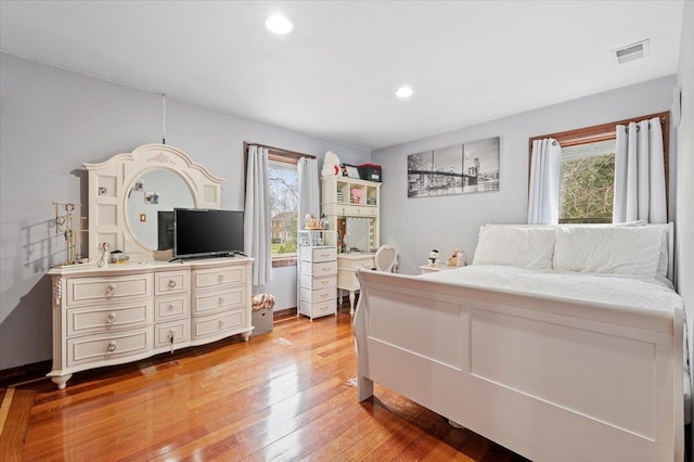 bedroom with light wood-style flooring, recessed lighting, multiple windows, and visible vents