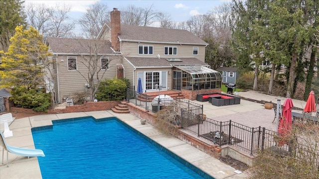 rear view of property featuring a patio area, roof with shingles, a chimney, fence, and an outdoor pool