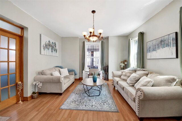 820 S Oak Dr, Bronx, NY 10467 - living area featuring wood finished floors, an inviting chandelier, and baseboards