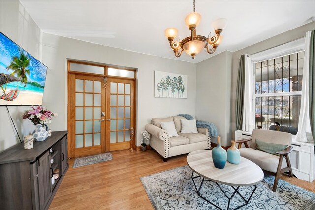820 S Oak Dr, Bronx, NY 10467 - sitting room with light wood-type flooring, french doors, and an inviting chandelier
