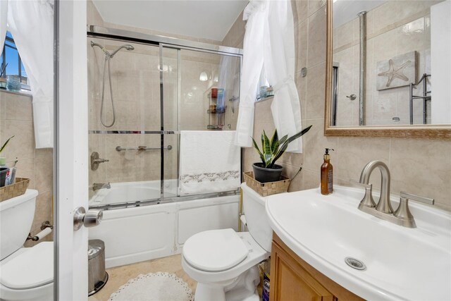 820 S Oak Dr, Bronx, NY 10467 - full bath featuring combined bath / shower with glass door, vanity, tile walls, and toilet