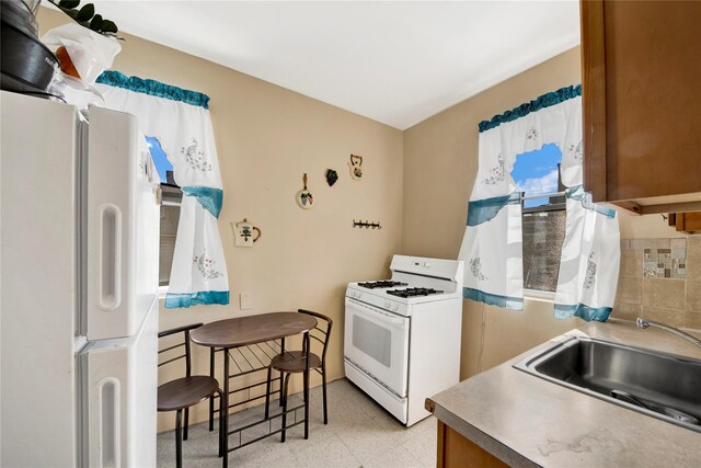 820 S Oak Dr, Bronx, NY 10467 - kitchen featuring tasteful backsplash, a sink, white appliances, and light floors
