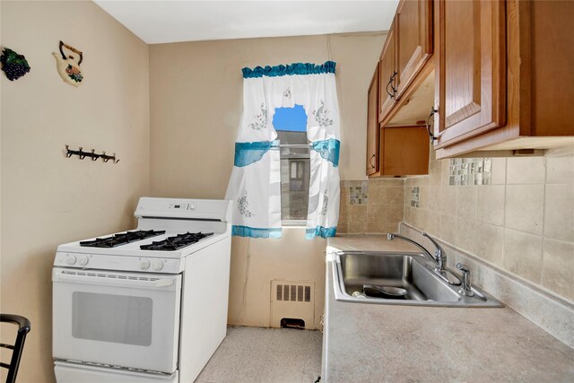 820 S Oak Dr, Bronx, NY 10467 - kitchen featuring white gas range oven, brown cabinets, radiator, decorative backsplash, and a sink