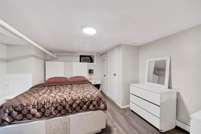 820 S Oak Dr, Bronx, NY 10467 - bedroom featuring baseboard heating, wood finished floors, and an AC wall unit