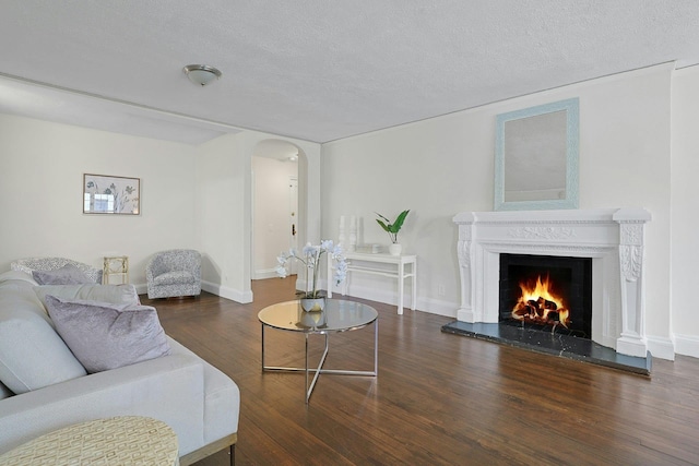 1273 N Ave Unit 1Ab, New Rochelle, NY 10804 - living area with wood finished floors, arched walkways, a lit fireplace, a textured ceiling, and baseboards