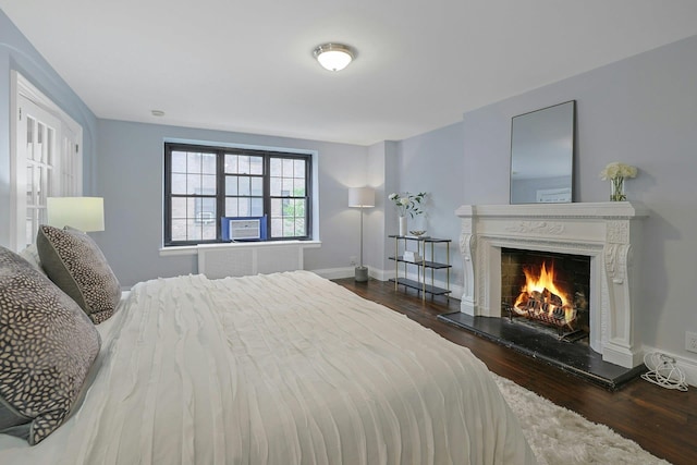 1273 N Ave Unit 1Ab, New Rochelle, NY 10804 - bedroom with wood finished floors, a lit fireplace, baseboards, and cooling unit
