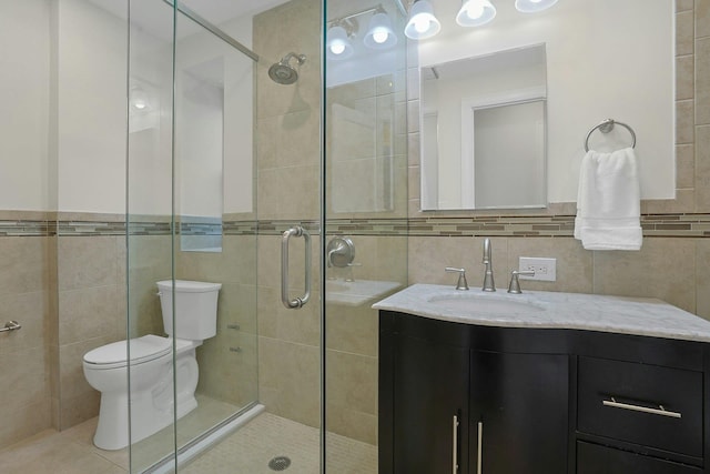 1273 N Ave Unit 1Ab, New Rochelle, NY 10804 - full bathroom featuring tile walls, a shower stall, toilet, vanity, and tile patterned floors