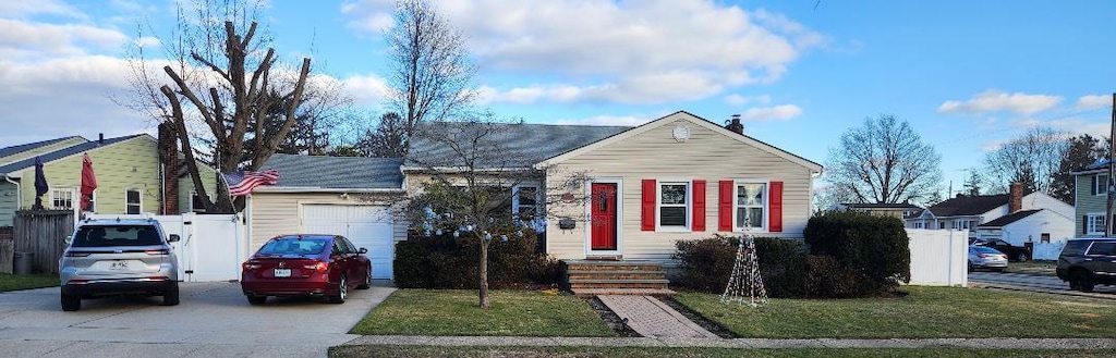 63 Spruce St, Hicksville, NY 11801 - view of front facade featuring a garage, fence, concrete driveway, and a front yard