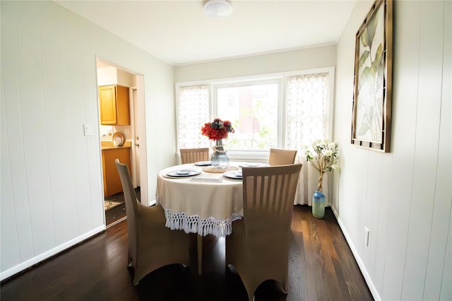 dining space with dark wood-style flooring and baseboards
