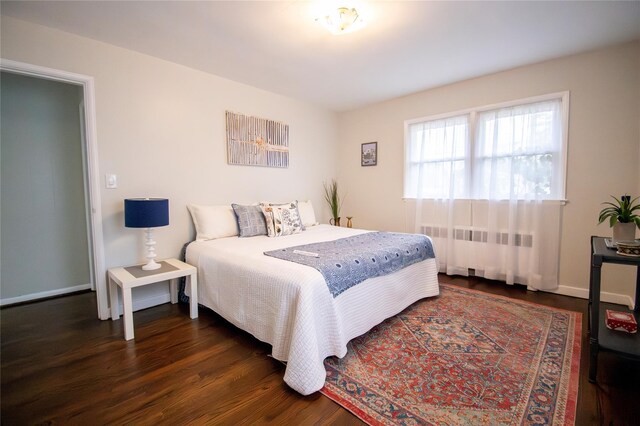 bedroom featuring radiator, baseboards, and dark wood-style floors
