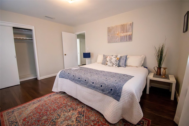 bedroom featuring wood finished floors, baseboards, a closet, and visible vents