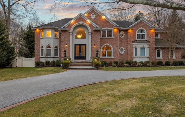 10 Red Maple Ln, Dix Hills, NY 11746 - view of front facade with brick siding, fence, a front lawn, and french doors