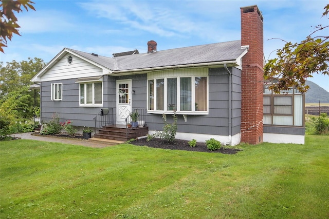 view of front of property featuring a front lawn and a chimney
