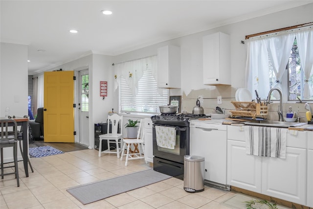 kitchen with gas range, white cabinetry, white dishwasher, and a sink