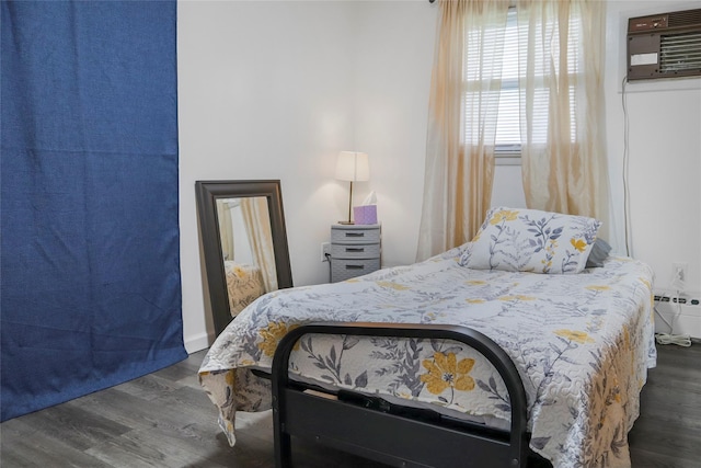 bedroom with wood finished floors and an AC wall unit