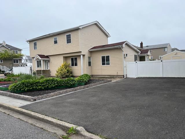 1 E Saltaire Rd, Lindenhurst, NY 11757 - view of front of property with fence and asphalt driveway