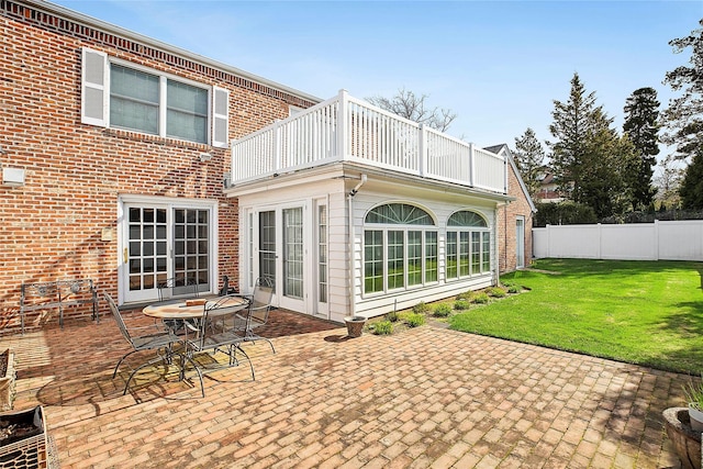 104 Grosvenor, Douglaston, NY 11363 - rear view of house featuring a lawn, a patio, brick siding, fence, and a balcony