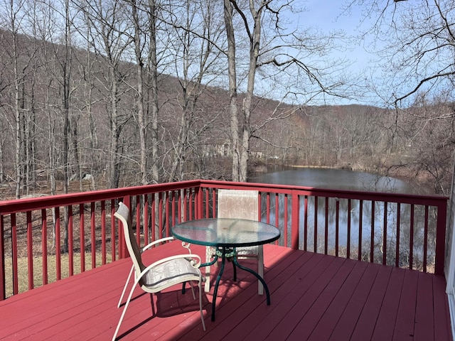 deck featuring a water view and a wooded view