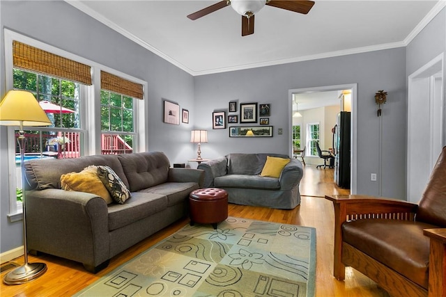 living area featuring a ceiling fan, a healthy amount of sunlight, and wood finished floors