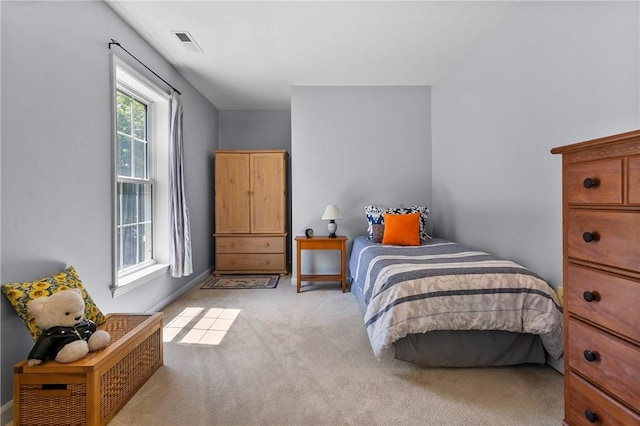 bedroom with visible vents and light carpet