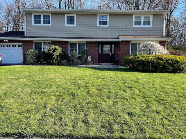 view of front of home with an attached garage, brick siding, and a front yard