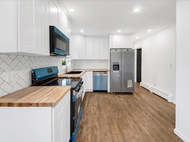 166 Sears Ave, Elmsford, NY 10523 - kitchen featuring stainless steel appliances, butcher block countertops, a sink, tasteful backsplash, and wood finished floors