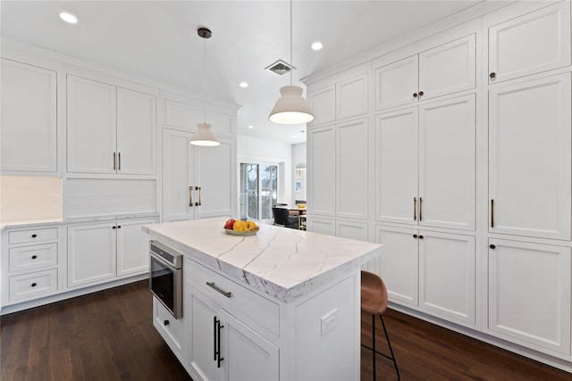 kitchen featuring visible vents, dark wood-style flooring, white cabinets, and decorative light fixtures