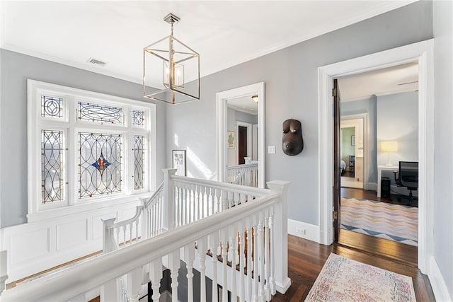 corridor featuring a notable chandelier, ornamental molding, an upstairs landing, visible vents, and dark wood-style floors