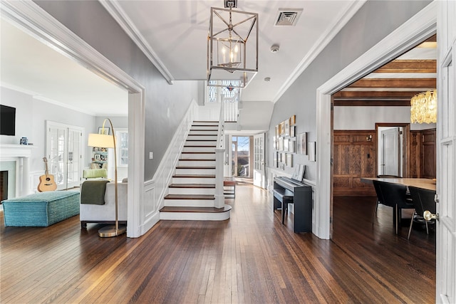 27 Calumet Ave, Hastings-On-Hudson, NY 10706 - entryway featuring a chandelier, stairs, dark wood finished floors, crown molding, and a fireplace