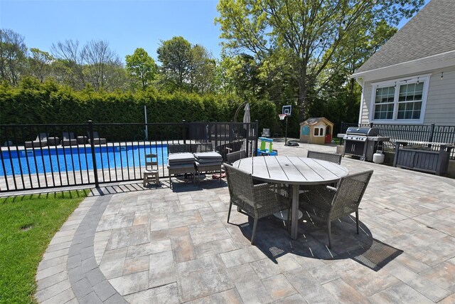 103 Silver Beech Ln, Calverton, NY 11933 - view of patio featuring fence, area for grilling, outdoor dining area, a fenced in pool, and an outbuilding
