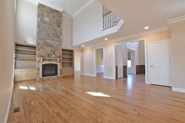 103 Silver Beech Ln, Calverton, NY 11933 - unfurnished living room featuring visible vents, crown molding, baseboards, light wood-style floors, and a high ceiling