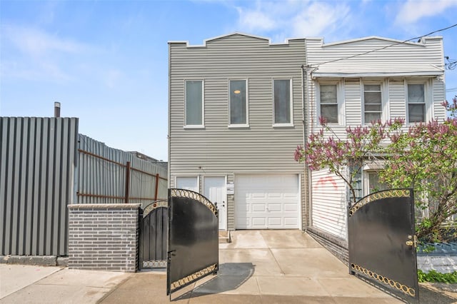 view of front of home with concrete driveway, an attached garage, and fence