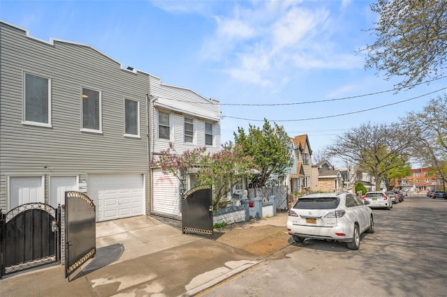 view of front of house with a garage, a residential view, and driveway